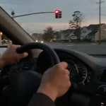 Driver's hands on a shaking steering wheel while stopped at a red light in Colonia, NJ